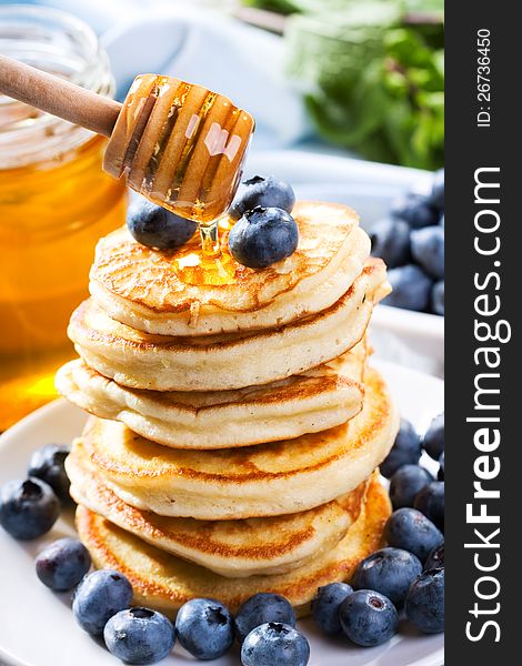 Pancakes with pouring honey and fresh blueberry