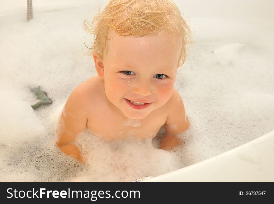 Happy child bathes in a bathroom