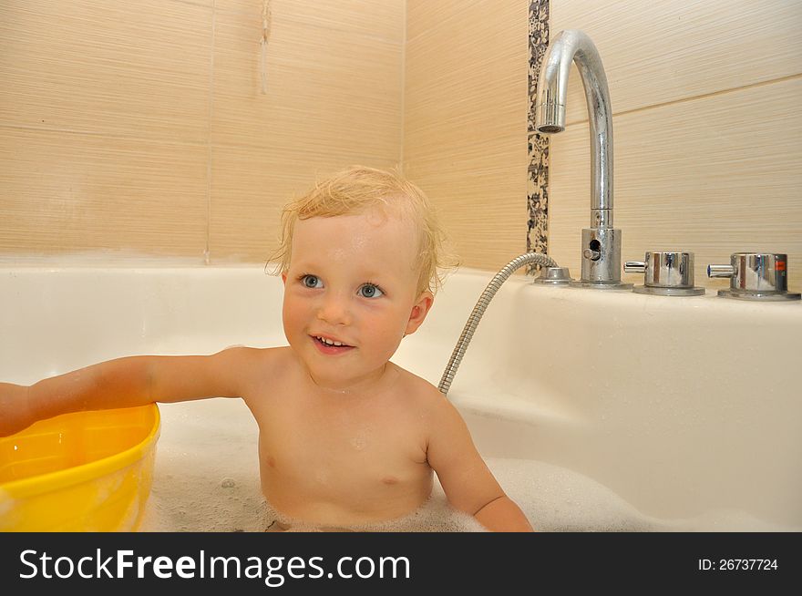 Happy child bathes in a bathroom