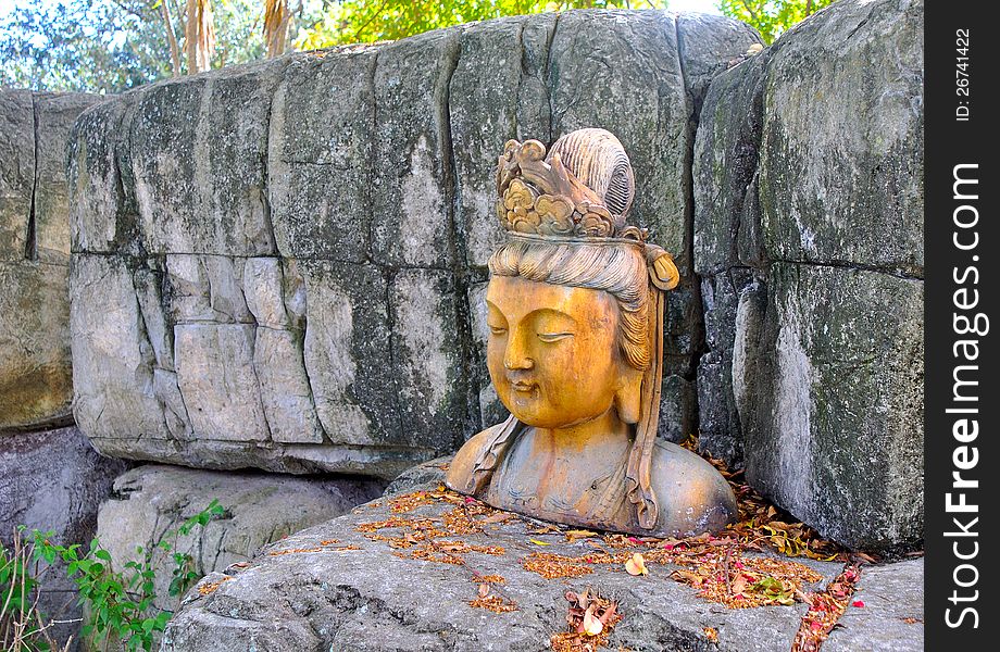 A statue of an Asian woman, in the shade, in a park. A statue of an Asian woman, in the shade, in a park.