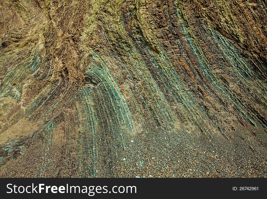 Layered rock texture of a cliff shore with many colors for individual layers. Layered rock texture of a cliff shore with many colors for individual layers