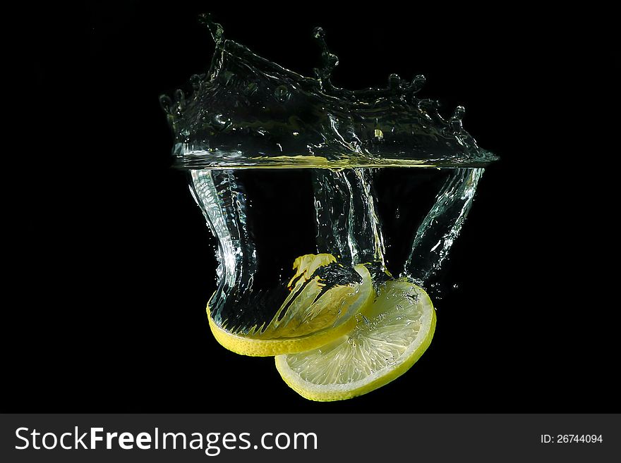 Picture of a fruit - sliced lemon dropped under water. Picture of a fruit - sliced lemon dropped under water