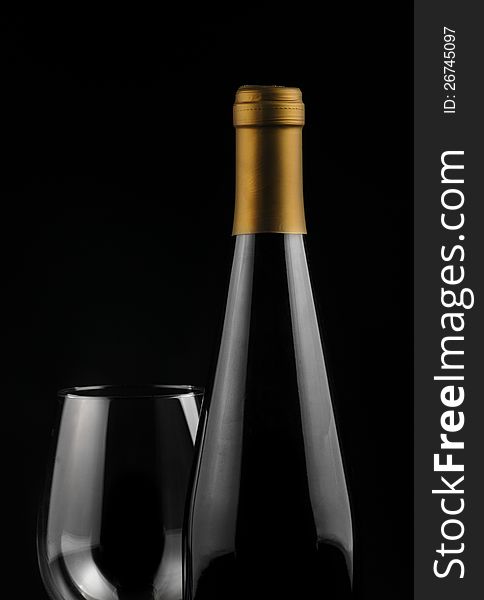 Close up of a bottle of wine and a glass over black background. Close up of a bottle of wine and a glass over black background
