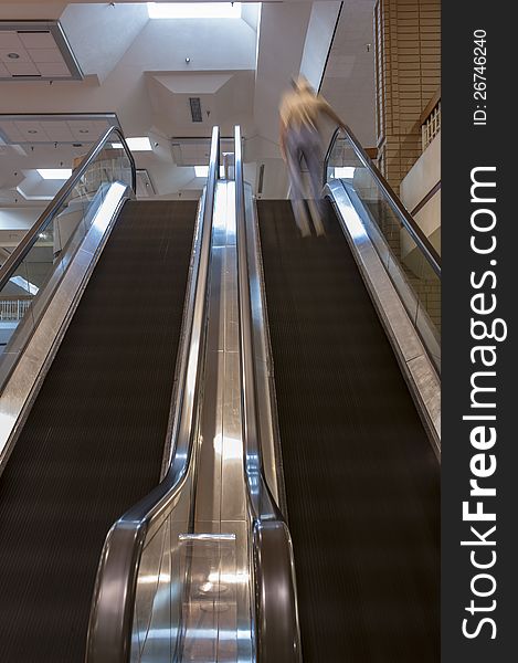 Dual escalators with steps blurred by motion inside a shopping mall. Dual escalators with steps blurred by motion inside a shopping mall.