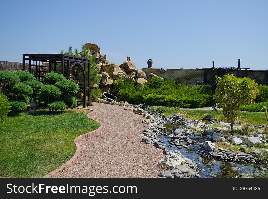 Peaceful park in the summer with an arbor and a stream. Peaceful park in the summer with an arbor and a stream