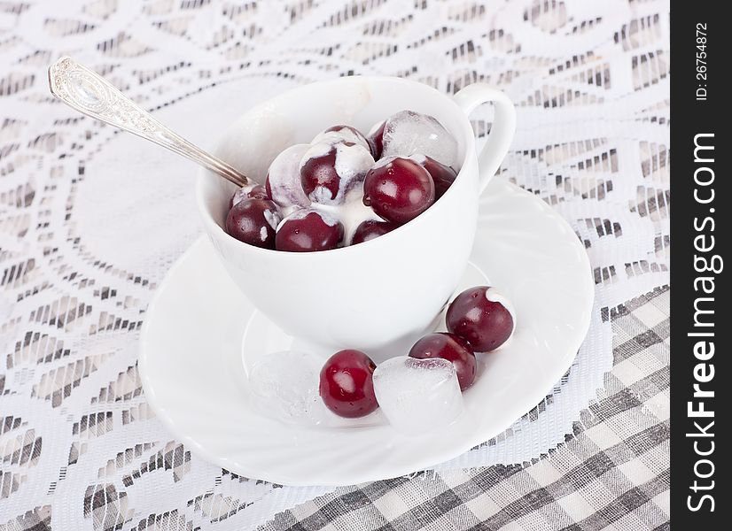 White cup with cherries ,cream and ice. White cup with cherries ,cream and ice