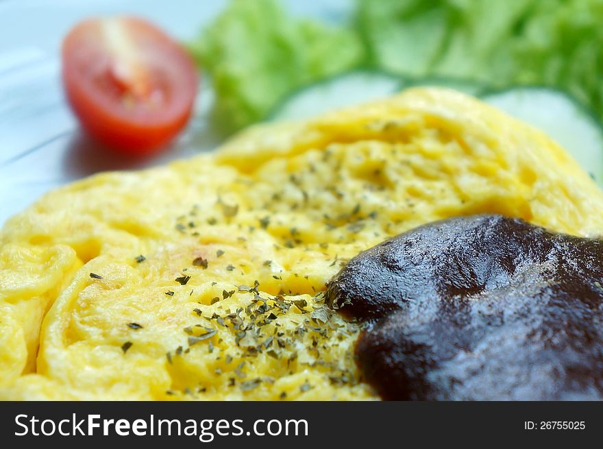 Scrambled eggs with blackpepper sauce and slice of tomato