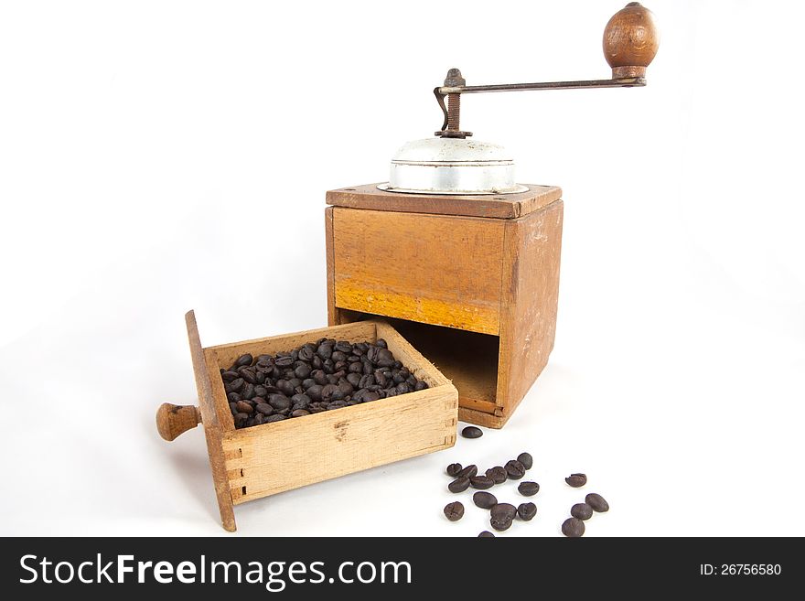 An old coffee grinder with coffee beans.