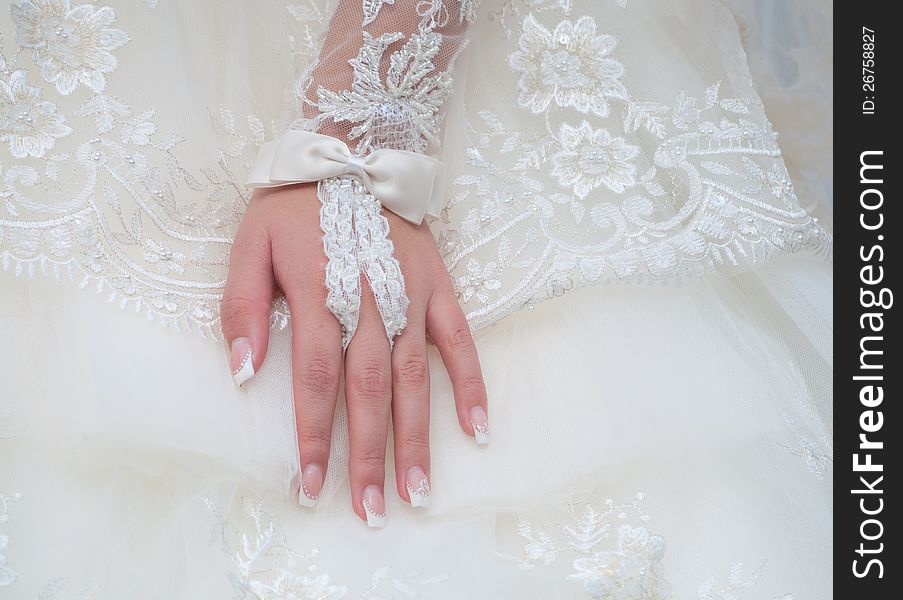 Bride hand on the white dress background