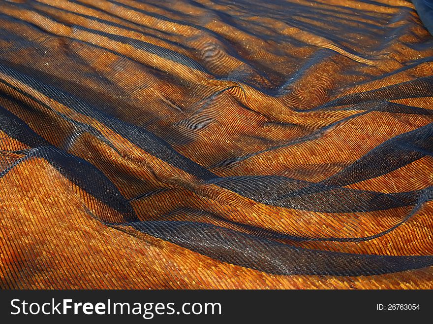 Black Netting covering an orange artificial turf. Black Netting covering an orange artificial turf