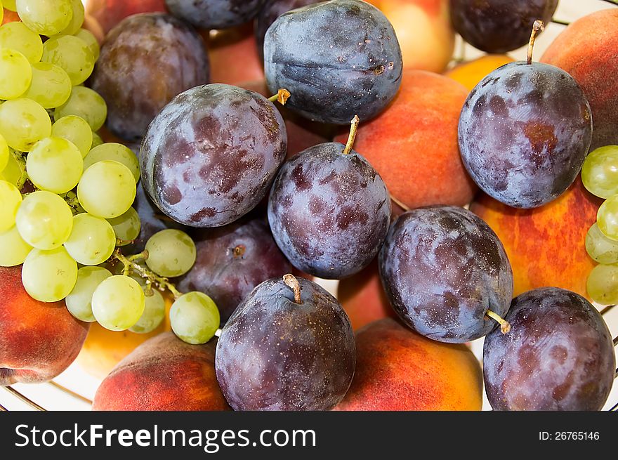 Mix of autumn fruits, close-up:grapes,plums,apple,peach