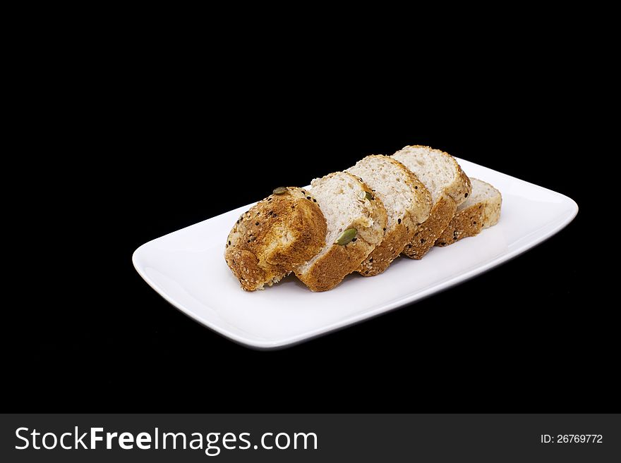 Fresh wholewheat bread with sunflower seeds Sesame and slices on black background