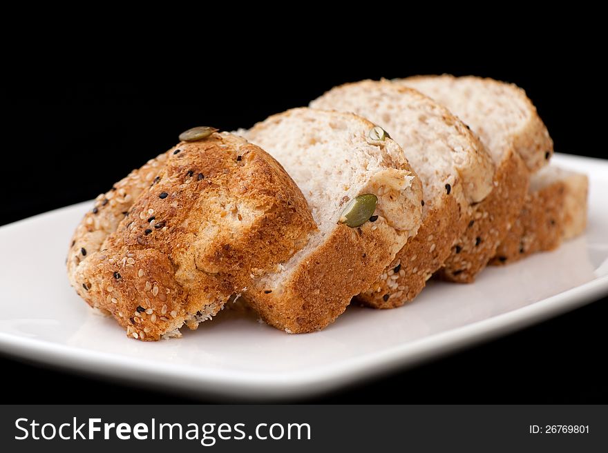 Fresh wholewheat bread with sunflower seeds Sesame and slices on black background