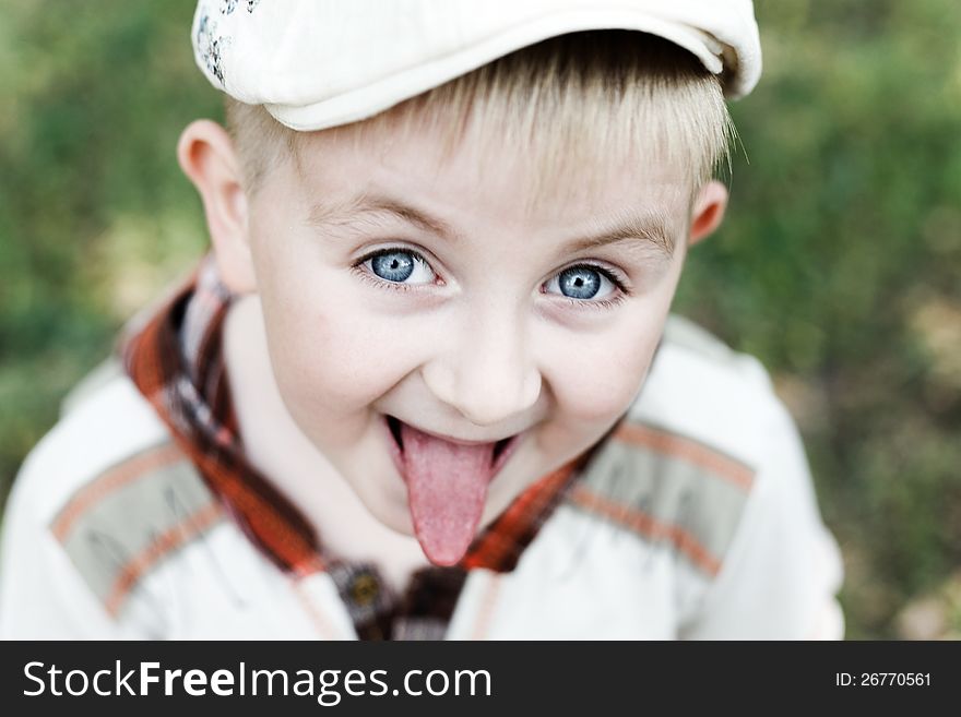 Portrait of a boy wearing a cap Tongue