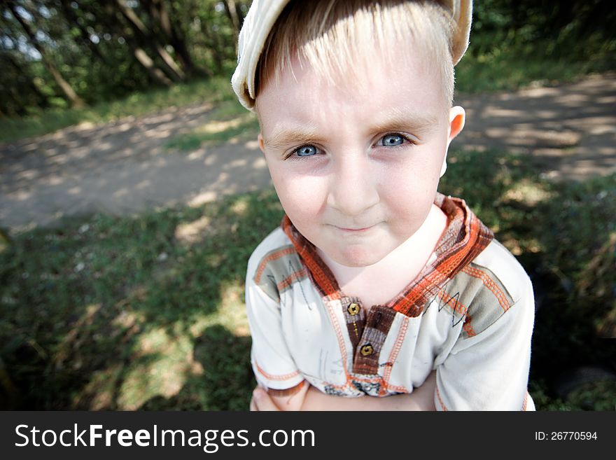 Portrait of a boy wearing a cap near the forest