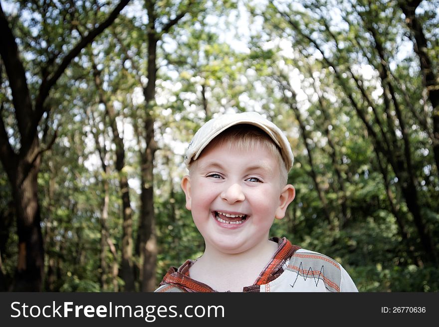 Portrait of a laughing boy in the woods