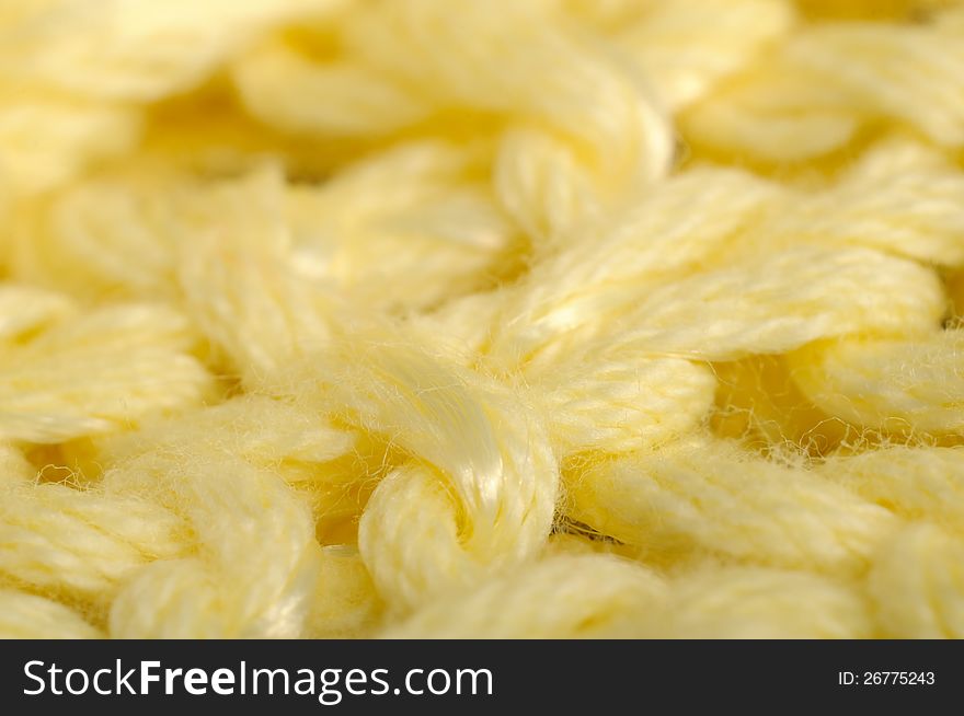 A super macro shot of yellow knitted fabric. A super macro shot of yellow knitted fabric