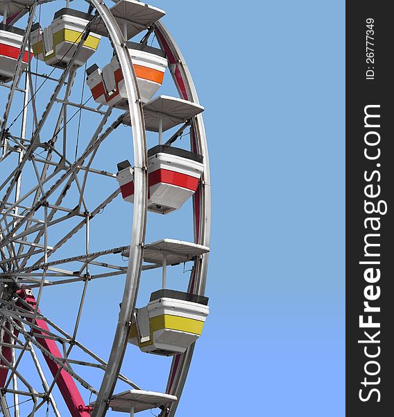 Close-up of a section of a ferris wheel with empty seats, with room for copy and text. Isolated against a blue sky. Close-up of a section of a ferris wheel with empty seats, with room for copy and text. Isolated against a blue sky.