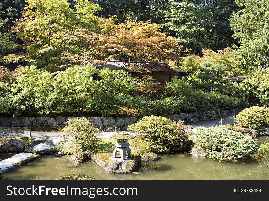 Beautiful Japanese garden with traditional lantern, pond, house, maple, and path. Beautiful Japanese garden with traditional lantern, pond, house, maple, and path.