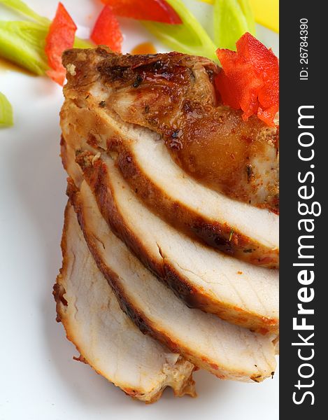 Slices of Grilled Chicken Breast with Vegetables close up on white plate