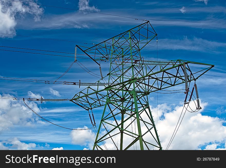 Electric support with wires and insulators against the cloudy sky