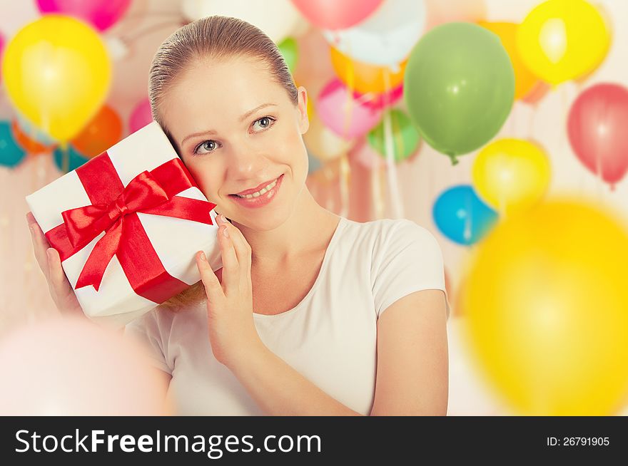 Young woman with a gift with colorful balloons