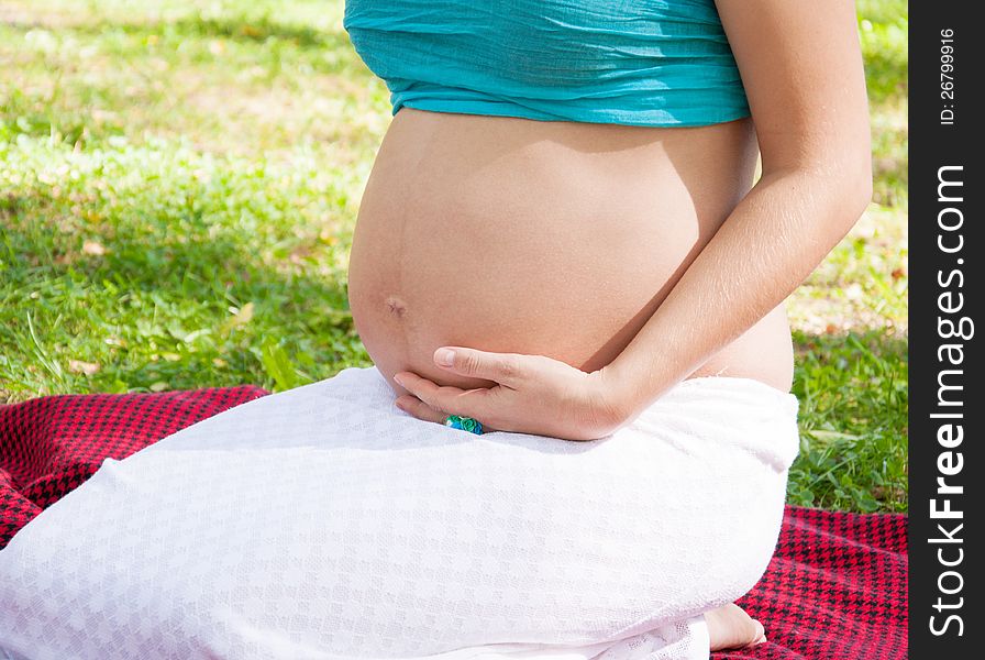 Prengnat woman caressing her huge belly at open air. Prengnat woman caressing her huge belly at open air