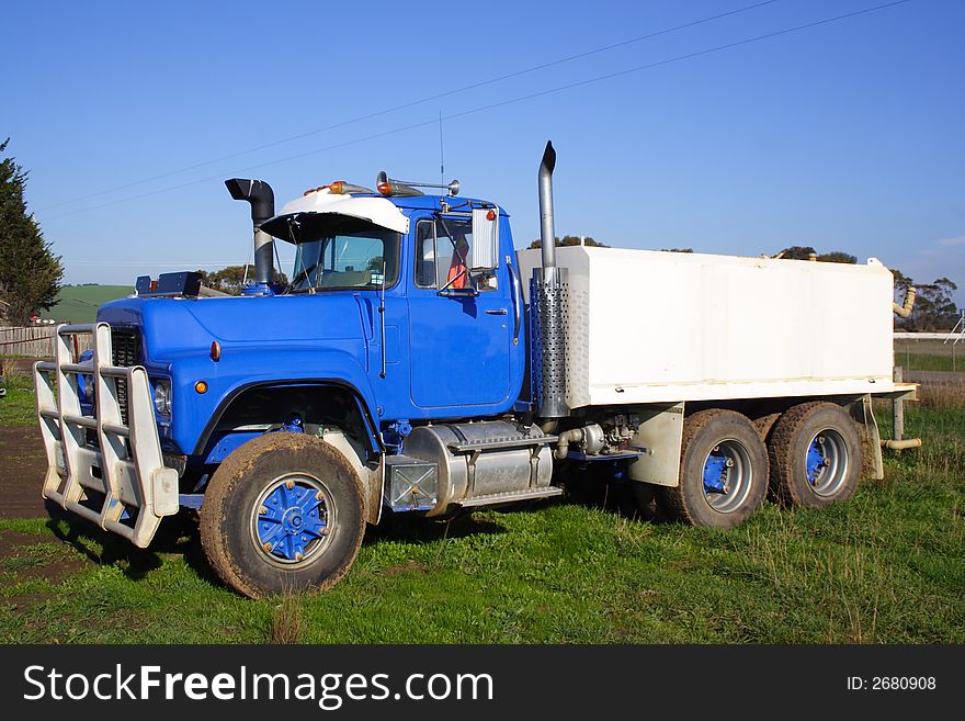 Small blue truck parked on green grass. Small blue truck parked on green grass