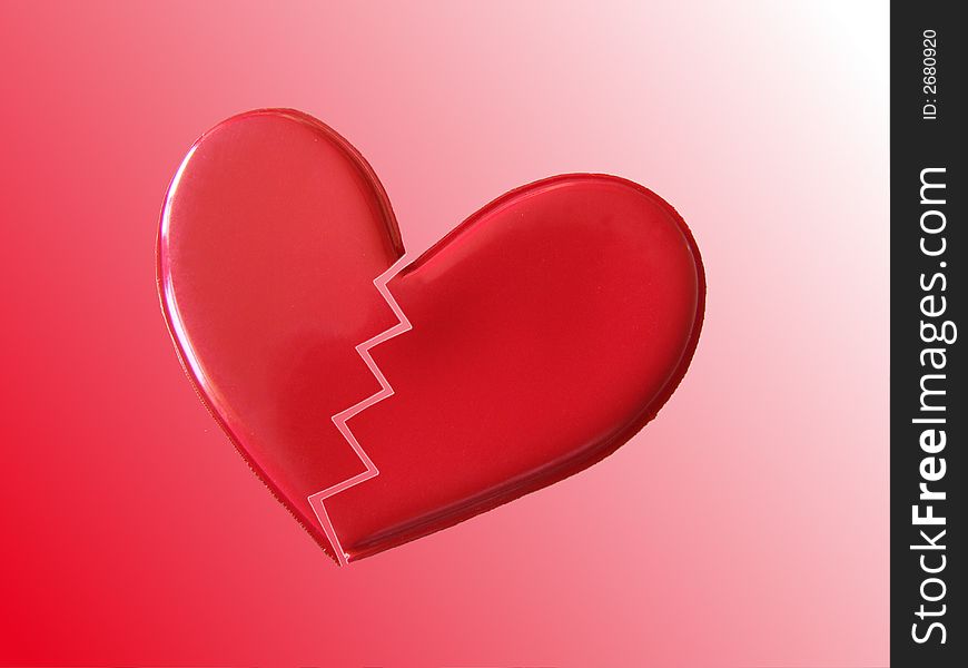 A red heart broken in two on a red and white background. A red heart broken in two on a red and white background