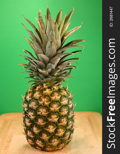 Ripe Pineapple on Green Background