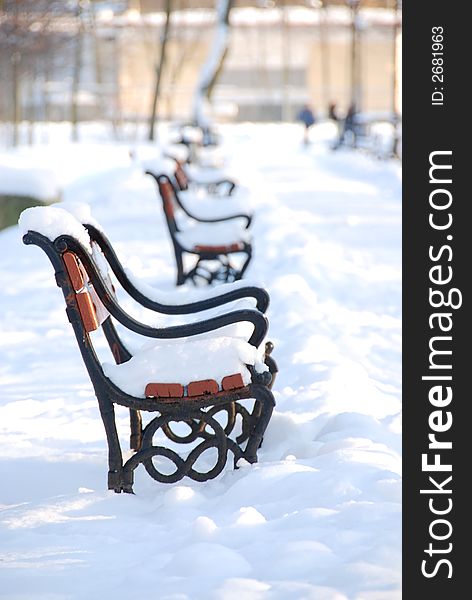 Red benches in a park covered with snow. Red benches in a park covered with snow