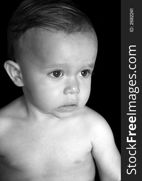 Black and white image of beautiful toddler with a thoughtful look on his face