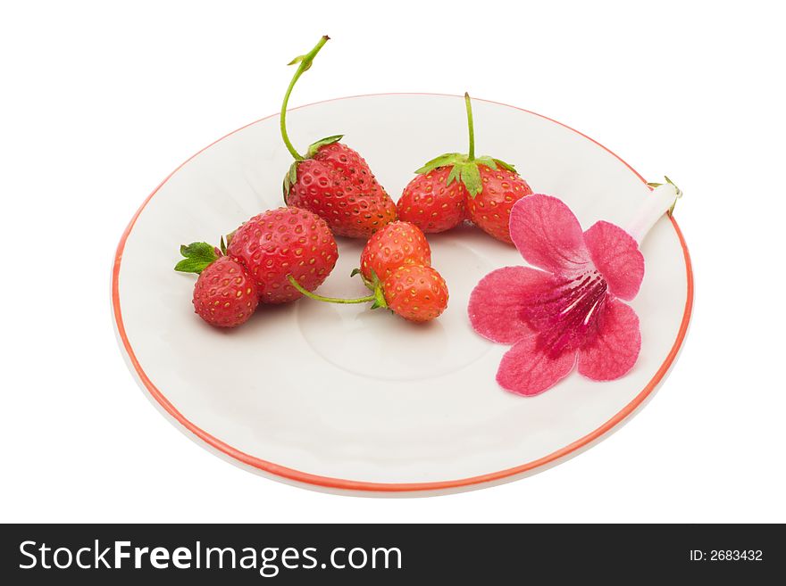 Strawberries and a flower on a saucer, isolated on white background, with clipping path in the file. Strawberries and a flower on a saucer, isolated on white background, with clipping path in the file