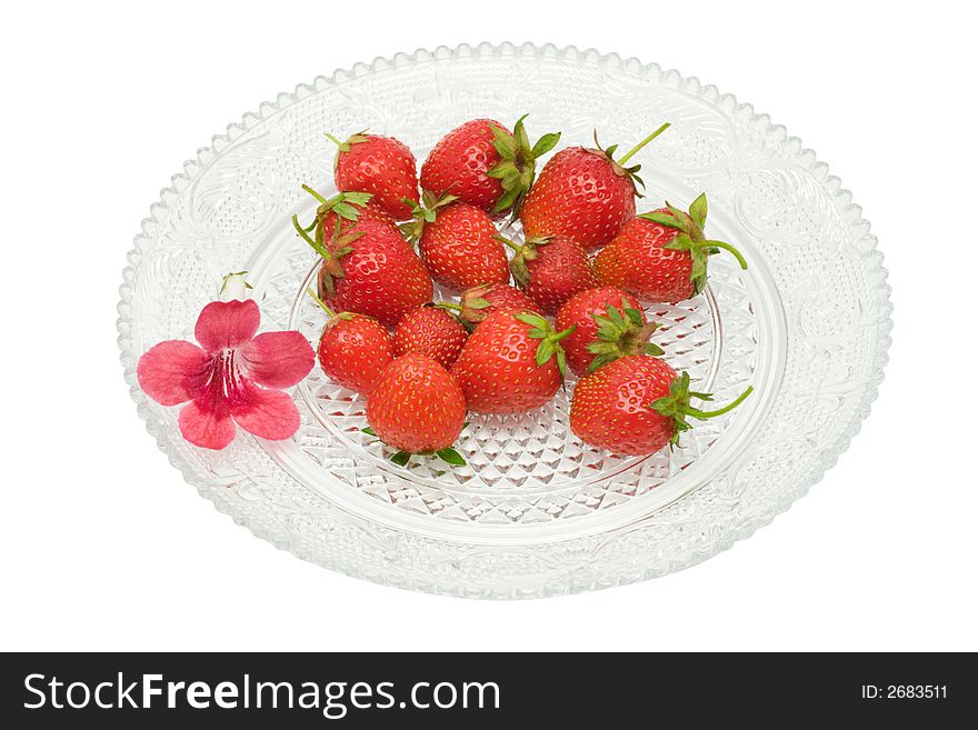 Strawberries and a flower on a glass dish, isolated on white background, with clipping path in the file. Strawberries and a flower on a glass dish, isolated on white background, with clipping path in the file