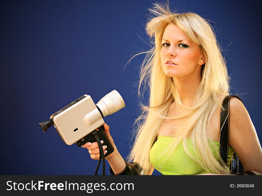 Young girl on the blue background and movie's films with camera in the hand. Young girl on the blue background and movie's films with camera in the hand