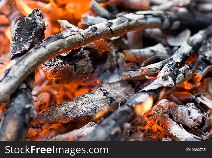 Closeup of burning firewoods with glowing charcoal.