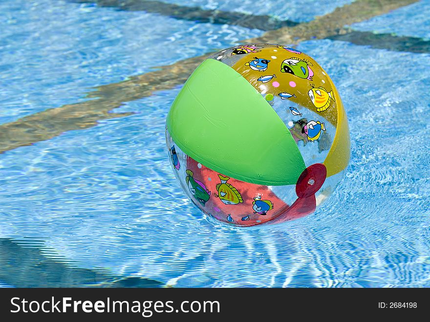 Colorful inflatable ball on water surface in pool. Colorful inflatable ball on water surface in pool