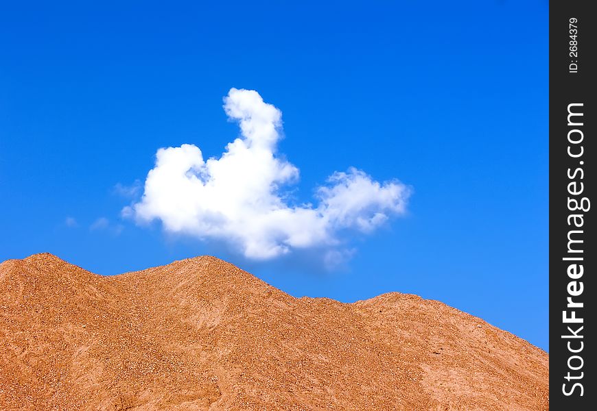 Sandy mountains on a background of the is bright blue summer sky. A bright background on a theme of summer holiday.