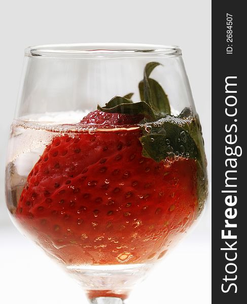 Single strawberry in a glass with ice on white background. Single strawberry in a glass with ice on white background