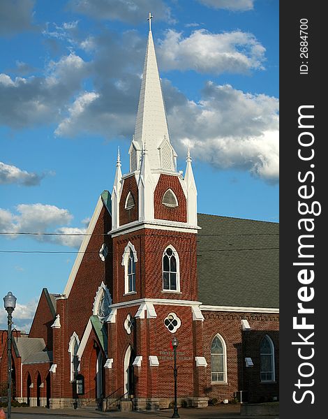Iconic Brick Church with white Steeple toped with a Cross. Iconic Brick Church with white Steeple toped with a Cross