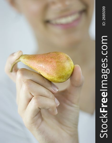 Smiling girl holding fresh pear. Smiling girl holding fresh pear