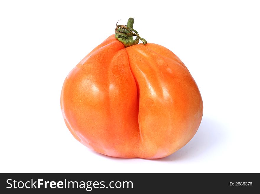 A very big and particular red/orange tomato side view. A very big and particular red/orange tomato side view
