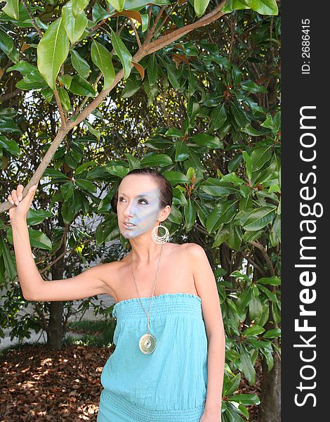 A makeup model standing next to a magnolia tree. A makeup model standing next to a magnolia tree