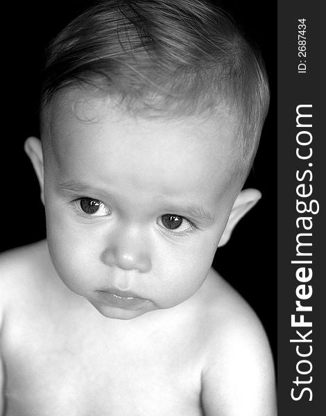Black and white image of beautiful toddler with a thoughtful look on his face