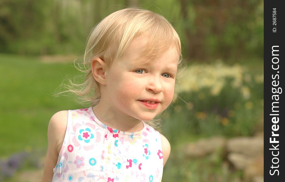 A pretty little girl (almost 3 years old) outside in a flowered dress. A pretty little girl (almost 3 years old) outside in a flowered dress