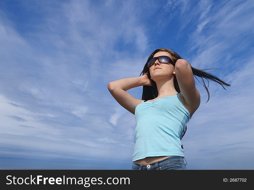 Portrait of young beautiful girl over sky background