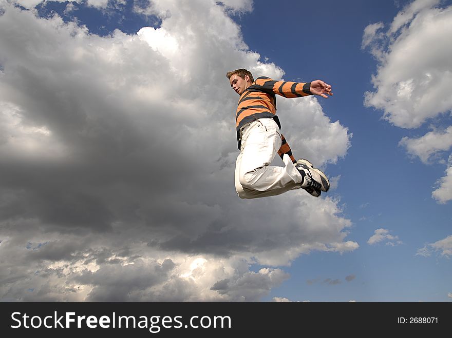 Young man happily jumping against blue sky. Young man happily jumping against blue sky.