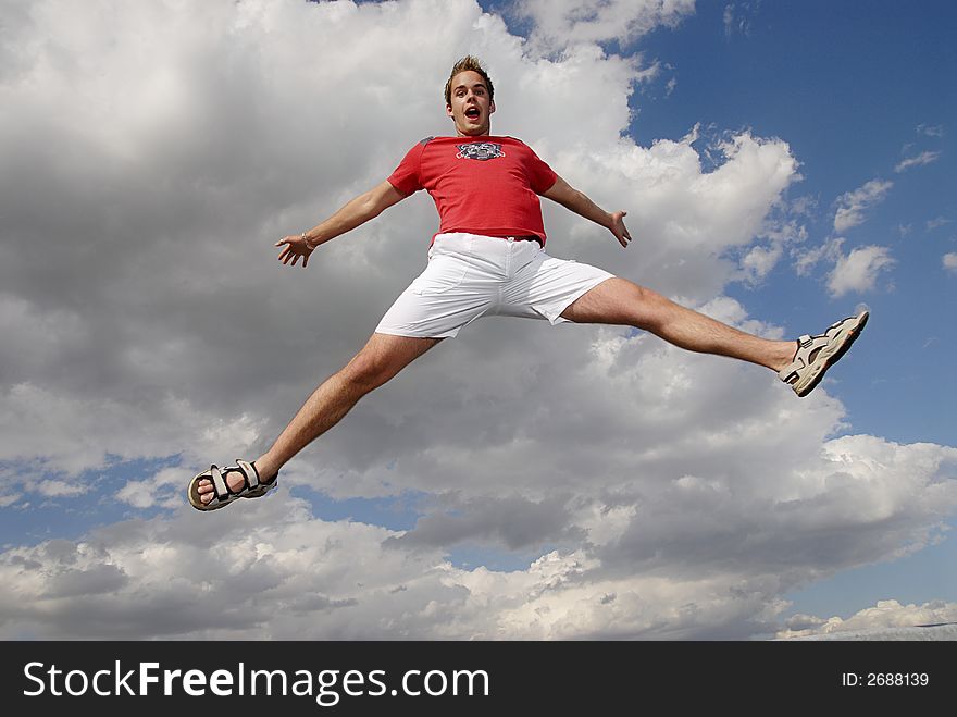 Young man happily jumping against blue sky. Young man happily jumping against blue sky.