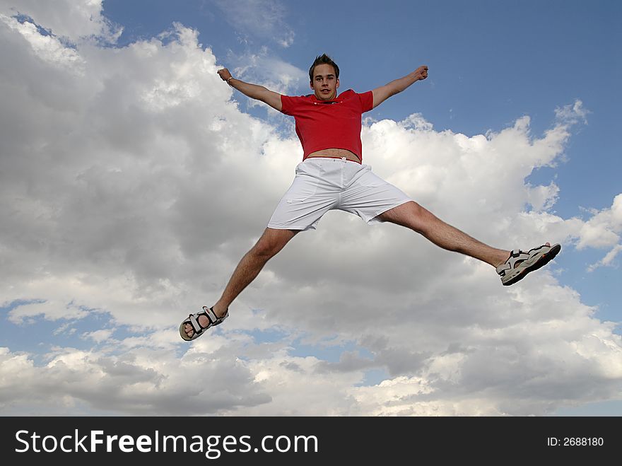 Young man happily jumping against blue sky. Young man happily jumping against blue sky.