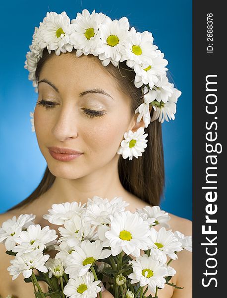 Young, beautiful and modest woman with bouquet of white flowers. Blue background. Young, beautiful and modest woman with bouquet of white flowers. Blue background